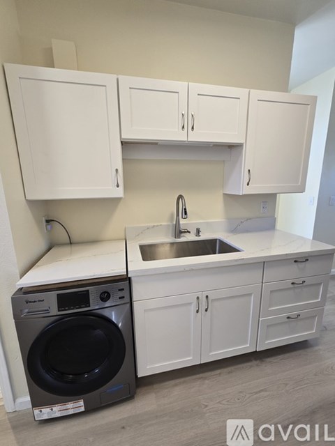 A modern kitchen with white cabinets and a black dishwasher.