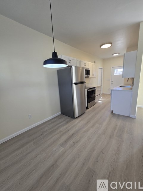 A kitchen with a refrigerator, oven, and microwave.