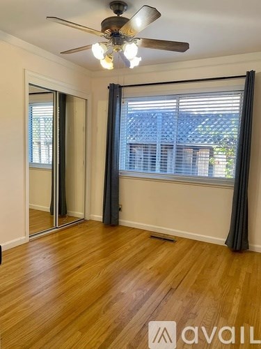 A room with wooden floors and a ceiling fan.