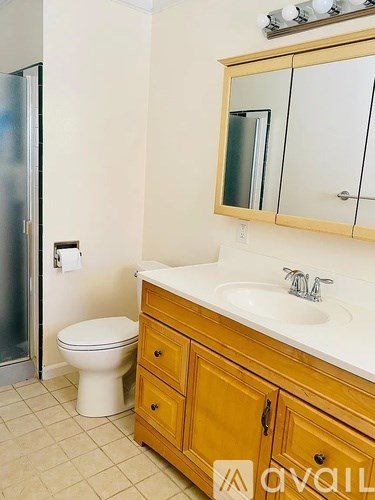 A bathroom with a toilet, sink, and mirror.