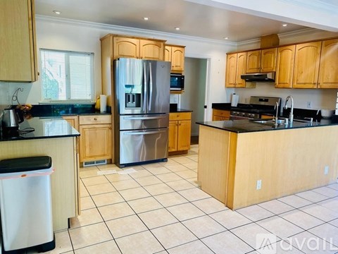 A kitchen with wooden cabinets and a black counter top.