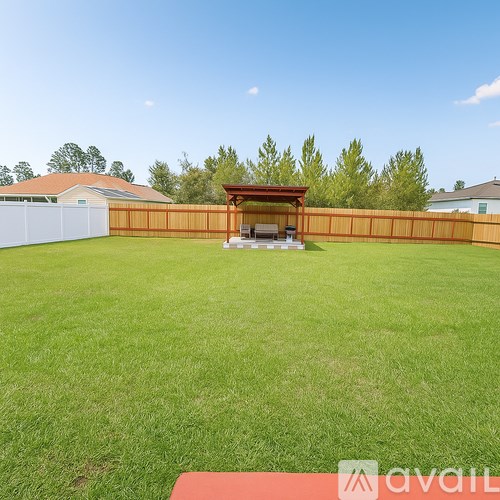A backyard with a wooden fence and a gazebo.
