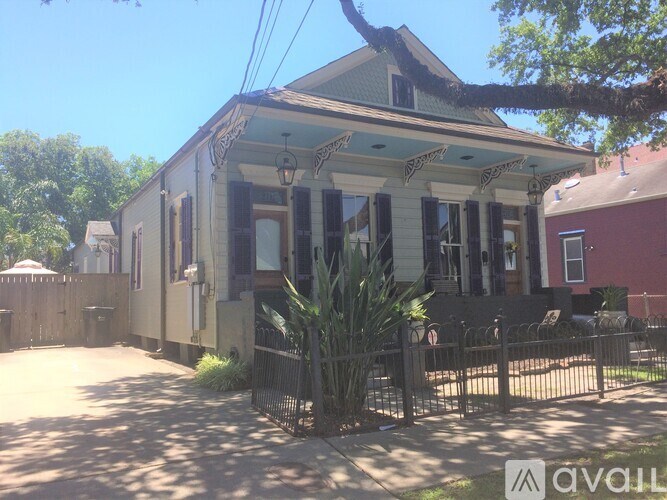 A house with a blue roof and a fence in front of it.