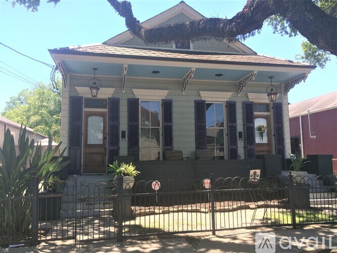 A house with a blue roof and a black fence.