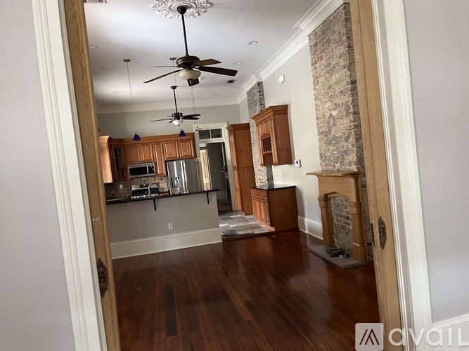 A living room with a fireplace and a ceiling fan.