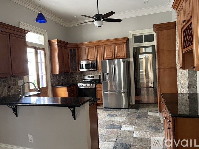 A kitchen with a black counter top and wooden cabinets.
