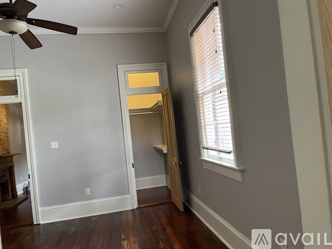 A room with a ceiling fan and a window with blinds.