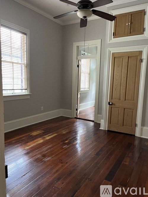 A room with a ceiling fan and wooden floors.