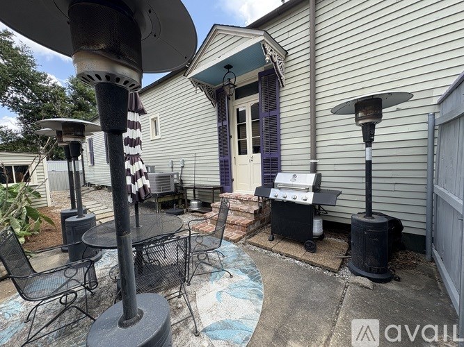 A patio with a grill and chairs.