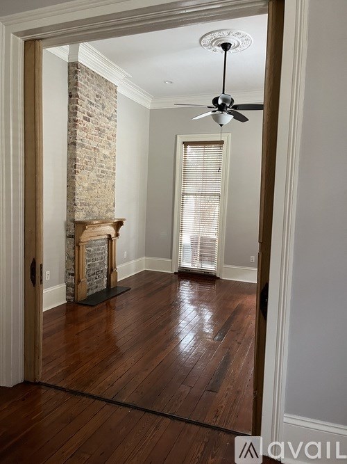 A room with a brick column and a ceiling fan.