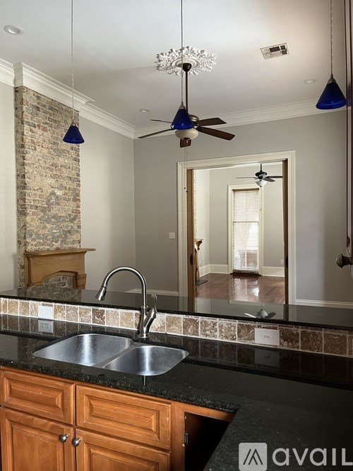A kitchen with a stone fireplace and a large mirror.