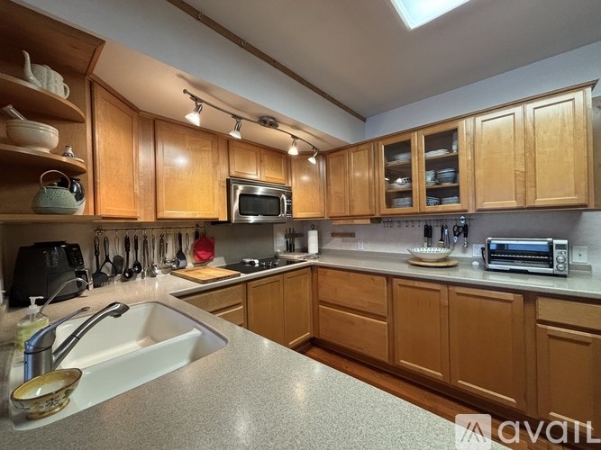 A kitchen with wooden cabinets and a white sink.