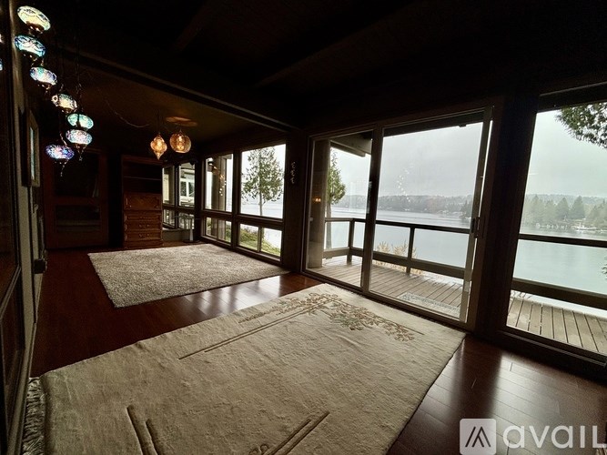 A room with a view of a lake through large windows.