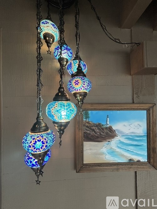 A row of hanging lamps with blue and turquoise glass shades.