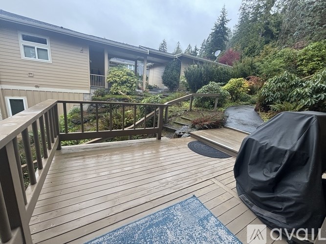 A balcony with a blue rug and a black chair is available.