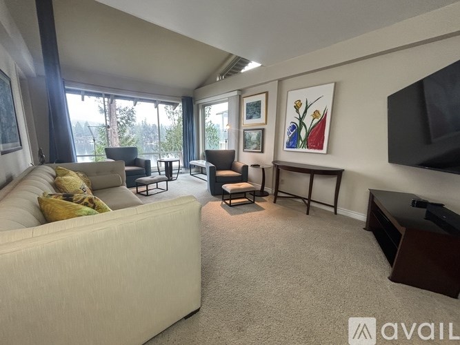 A living room with a couch, chairs, and a television.