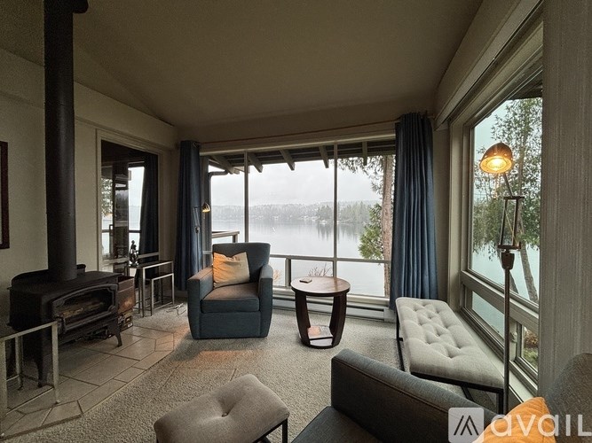 A living room with a wood stove and a view of the water.