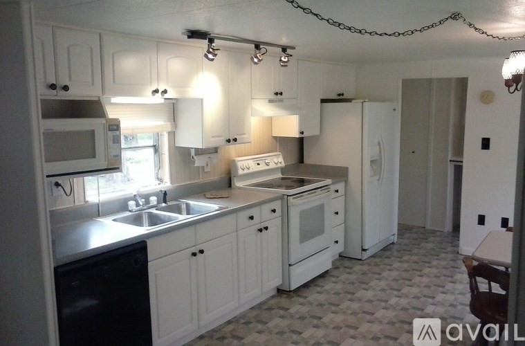 A kitchen with white cabinets and a black dishwasher.