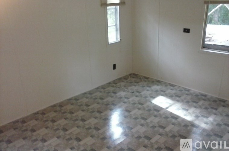 A room with a tiled floor and two windows.