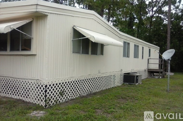 A white mobile home with a satellite dish on the roof.