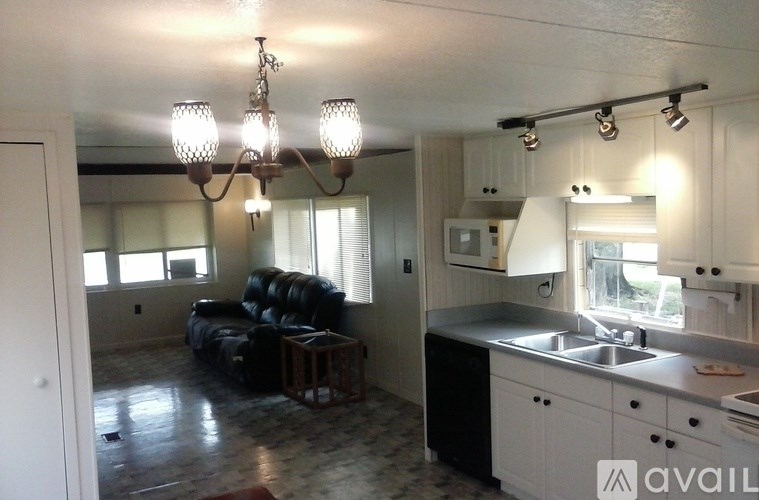 A kitchen with a sink, stove, and cabinets.