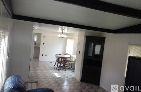A living room with a black couch and a dining table.