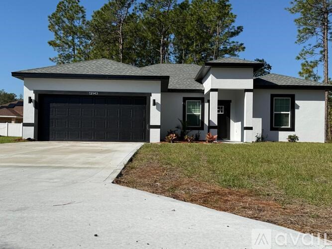 A two-story house with a garage door and a driveway.