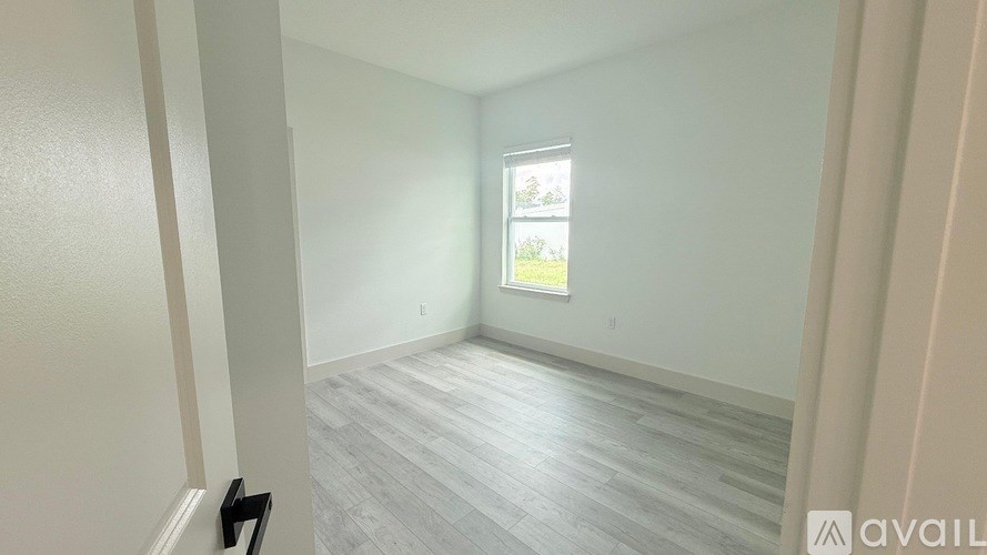 A room with a window and wooden flooring.