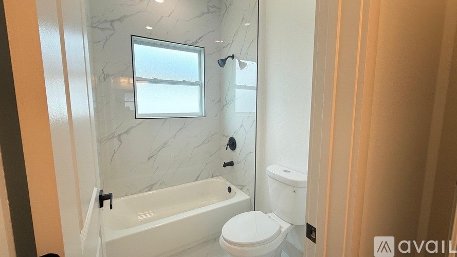 A bathroom with a marble wall and a window.