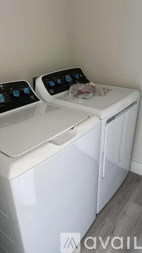 Two white washing machines are side by side.