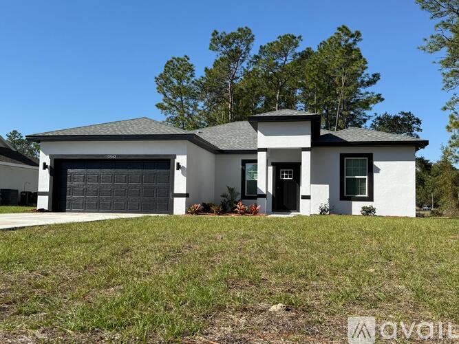 A modern house with a grey roof and white walls.