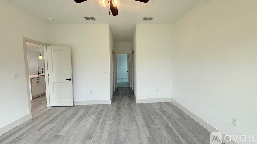 A spacious room with a ceiling fan and lighting fixture.