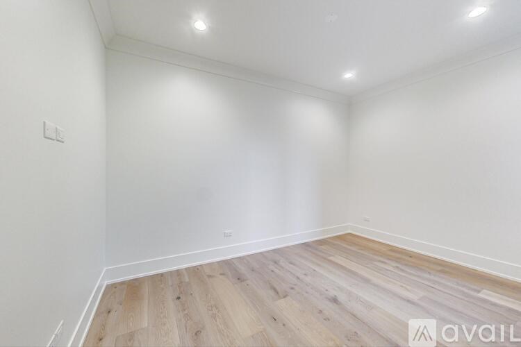 A room with wooden flooring and white walls.