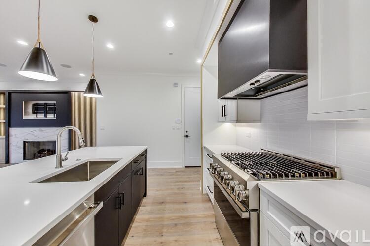 A modern kitchen with a white countertop and stainless steel appliances.