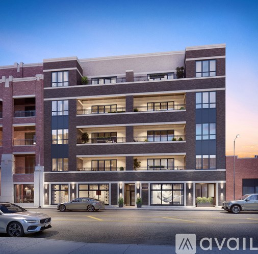 A modern multi-story building with cars parked in front.