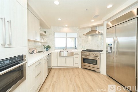 A kitchen with white cabinets and stainless steel appliances.