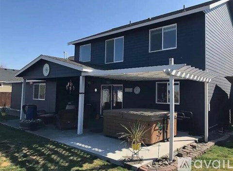 A house with a dark blue exterior and a covered patio area.