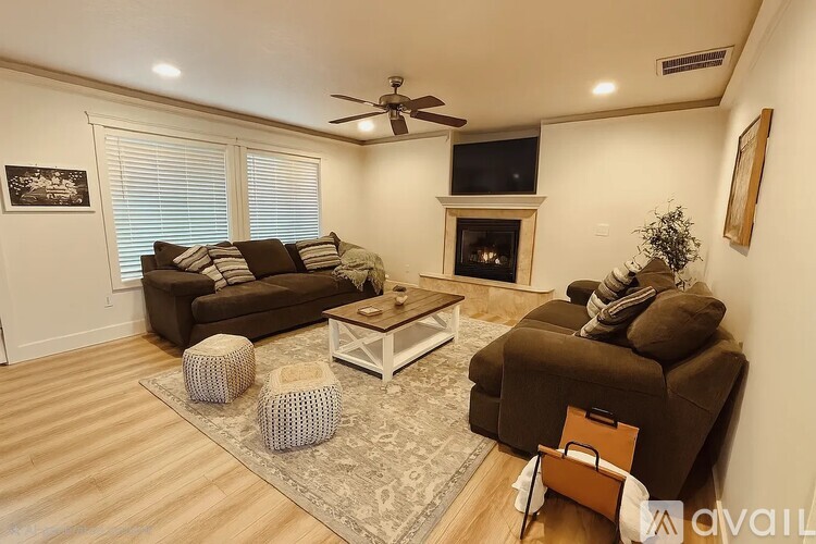 A living room with a brown couch, a white coffee table, and a fireplace.