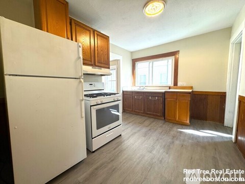 A kitchen with a white refrigerator, stove, and oven.