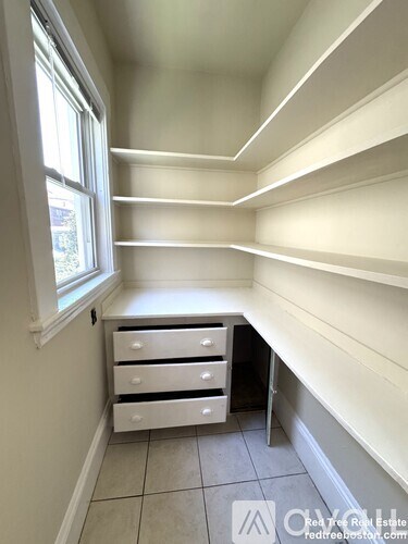 A white room with a window and drawers.