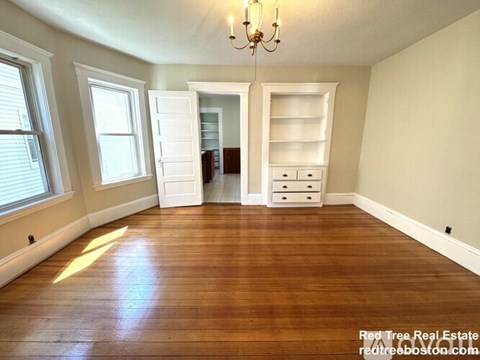 A room with wooden floors and a chandelier.