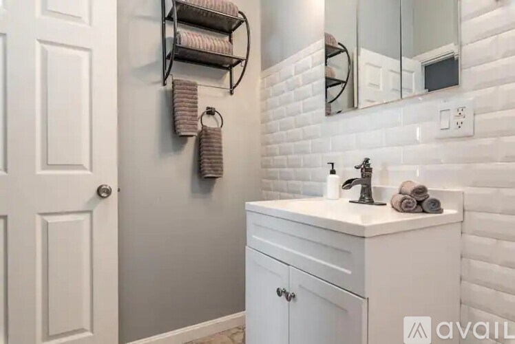 A bathroom with a white sink and a mirror above it.