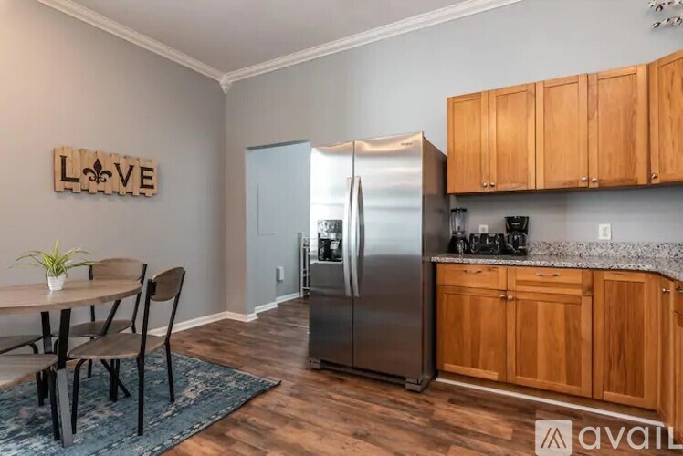 A kitchen with a refrigerator, cabinets, and a dining table.