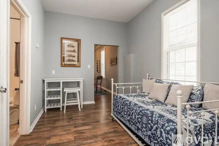 A bedroom with a bed, desk, and chair.