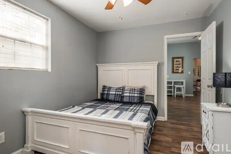 A bedroom with a bed, nightstand, and a window.