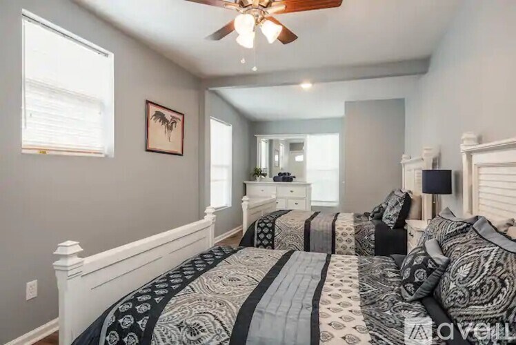 A bedroom with a bed, dresser, and mirror.