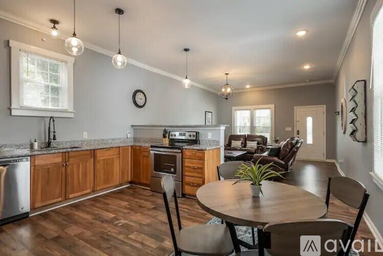 A kitchen with wooden cabinets and a round table with chairs.