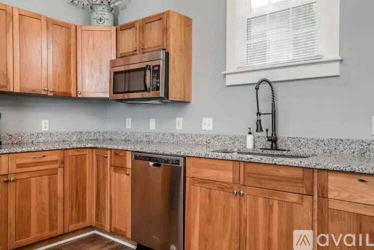 A kitchen with wooden cabinets and a granite countertop.