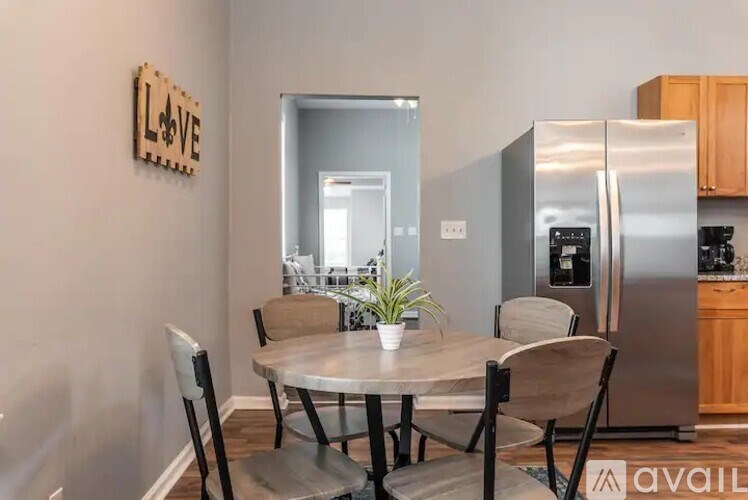 A kitchen with a table and chairs in the foreground and a refrigerator in the background.