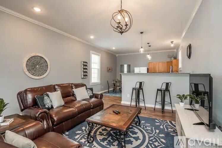 A living room with a brown leather couch and a wooden coffee table.